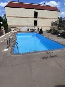 a blue swimming pool in front of a building at UNIVERSITY INN Winston in Winston-Salem