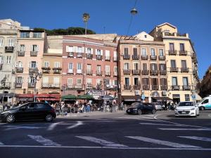 a busy city street with cars parked in front of buildings at Note Sulla Piazza in Cagliari