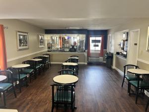 a restaurant with tables and chairs in a room at UNIVERSITY INN Winston in Winston-Salem