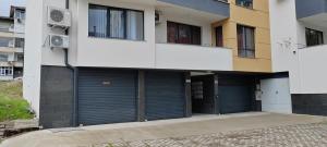 a building with two garage doors in front of it at Stylish Rose Garden Apartment with Balcony & Parking in Asenovgrad