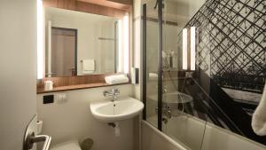 a bathroom with a sink and a toilet and a shower at Campanile PRIME - Nogent-sur-Marne in Nogent-sur-Marne +16 photos