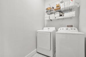 a white laundry room with a washer and dryer at Music Soul House in Atlanta