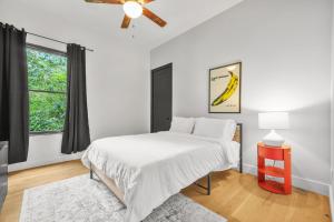 a white bedroom with a large bed and a window at Music Soul House in Atlanta