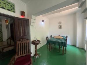 a table and chairs in a room with a green floor at Brenley B Bungalow in Talalla South