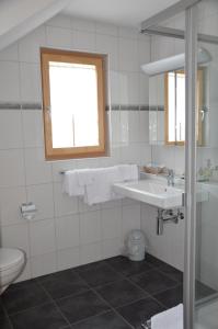 un bagno bianco con lavandino e WC di Hotel Gasthof Kreuz a Welschenrohr