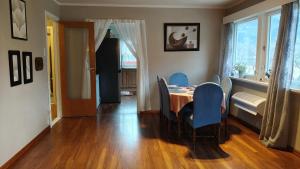 a dining room with a table and blue chairs at Stryn Norway in Stryn