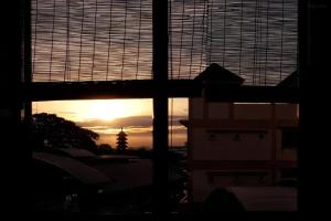 a view of the sunset through a window of a building at Photohostel in Bangkok
