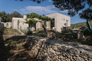 a stone retaining wall in front of a house at Oxalis Villas in Perlengiánika