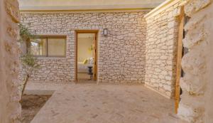 a room with a stone wall and a bathroom at Anima Ocean Lodges in Essaouira