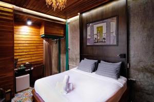 a bedroom with a large white bed with a chandelier at Photohostel in Bangkok