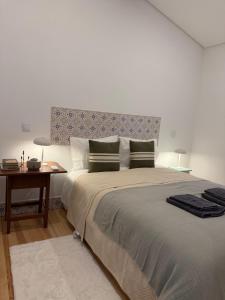 a bedroom with a large bed and a table at Casa da Ana - Casinhas com Alma in Torrão