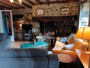 a living room with a couch and a fireplace at Maison Mignaquy in Charritte-de-Bas
