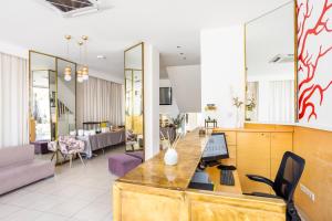 a living room with a desk with a computer on it at Coral Hotel - Hotelia Hospitality Group in Ierapetra