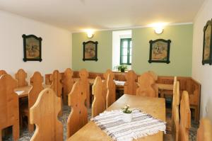 a dining room with a wooden table and chairs at Pluto Lovas Vendégház in Szilvásvárad