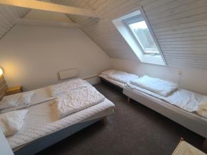 zwei Betten in einem Zimmer mit Fenster in der Unterkunft Læsø Efterskole in Læsø