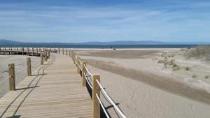 a wooden boardwalk on a beach with the ocean at Apartament Deportiva in Deltebre