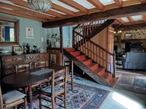 a dining room with a table and a staircase at Maison Mignaquy in Charritte-de-Bas