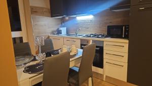 a kitchen with a table with chairs and a sink at Guest house Di Carlo in Sulmona
