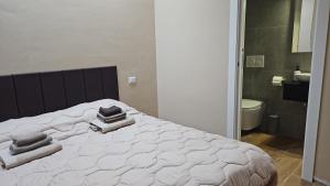 a bedroom with a white bed with towels on it at Guest house Di Carlo in Sulmona