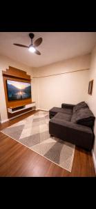 a living room with a couch and a flat screen tv at Edifício Marília in Marília