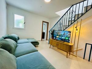 a living room with two couches and a flat screen tv at La casa del pinsapo in Yunquera