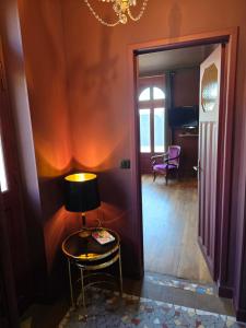 a table with a lamp on it next to a hallway at Le Castel Guesthouse in Bayeux