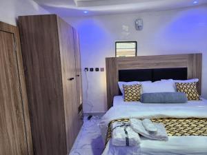 a bedroom with a large bed with shoes on it at Majesty Apartment in Asaba