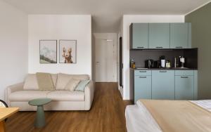 a living room with a couch and a kitchen at Limehome Wels Ringstraße in Wels +18 photos