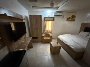 a bedroom with a bed and a television in it at Majesty Apartment in Asaba