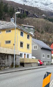 a yellow house on the side of a street at Green apartment in Odda