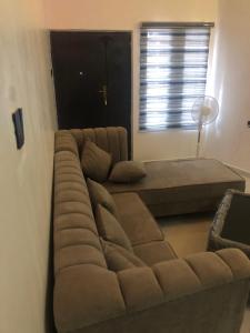 a large couch in a room with a window at The 7th Haven in Uyo