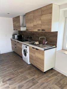 a kitchen with a sink and a washing machine at Maison f3 climatisée in Montceau-les-Mines