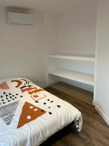 a bedroom with a bed with a comforter on it at Maison f3 climatisée in Montceau-les-Mines