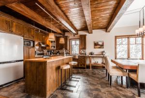 a kitchen with wooden cabinets and a table and a refrigerator at Chalet Le Mont-Blanc in Saint-Faustin