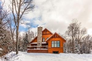 a cabin in the woods in the snow at Chalet Le Mont-Blanc in Saint-Faustin