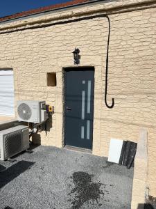 a door to a brick building with a fan at Maison f3 climatisée in Montceau-les-Mines