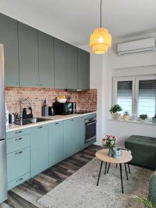 a kitchen with blue cabinets and a table at Apartment Ćulum in Peračko Blato