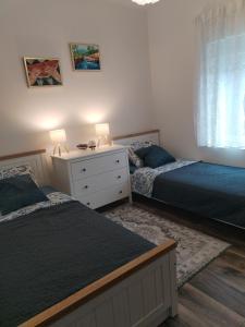 a bedroom with two beds and a dresser with two lamps at Apartment Ćulum in Peračko Blato +31 photos