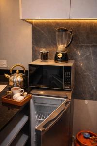 a kitchen with a blender on top of a microwave at Cozy Apartment in Munyonyo in Munyonyo