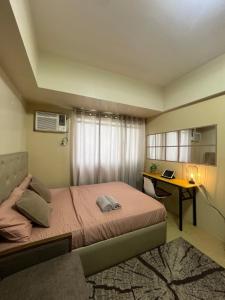a bedroom with a bed and a desk with a laptop at Avida Tower 2 in Davao City +13 photos