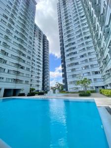 a swimming pool in front of two tall buildings at Avida Tower 2 in Davao City