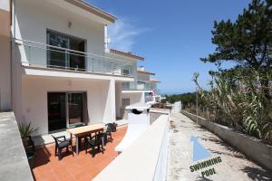 a house with a table and chairs on a patio at T3-Sitio do Surf in Nazaré
