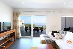 a living room with a couch and a television and a table at T3-Sitio do Surf in Nazaré