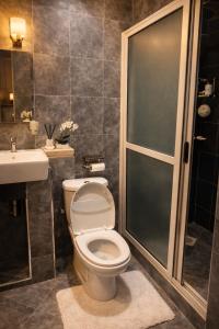 a bathroom with a toilet and a shower and a sink at Cozy Apartment in Munyonyo in Munyonyo