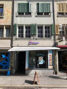 a building with an awning in front of a store at 1 Flat-Room Bern in Bern