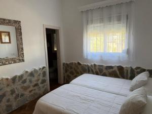 a bedroom with a bed and a mirror and a window at El Rancho in Tarifa