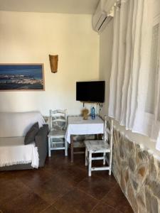 a living room with a television and a table with chairs at El Rancho in Tarifa