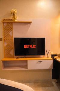 a flat screen tv sitting on top of a shelf at Cozy Apartment in Munyonyo in Munyonyo