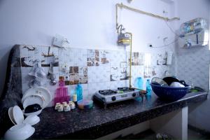 a kitchen counter with a stove and a sink at Tajiva Stay in Agra