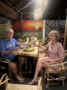 a man and a woman sitting at a table at Woodland villa in Arusha +62 photos